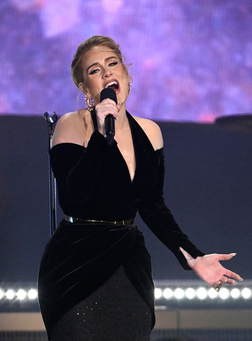 Adele singing on stage in a black outfit 