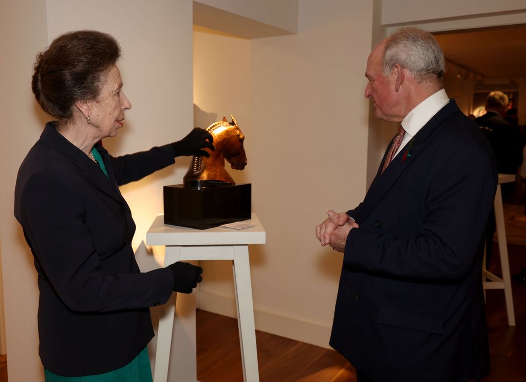 Princess Anne and a man looking at a small horse statue