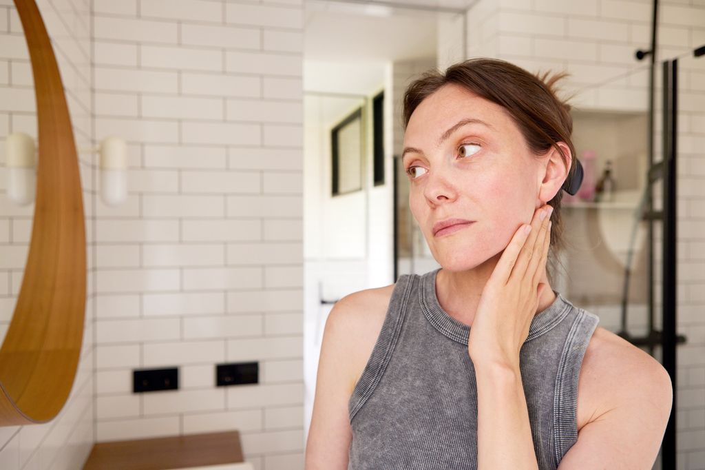 Mid adult woman examining her reflection in the bathroom mirror,