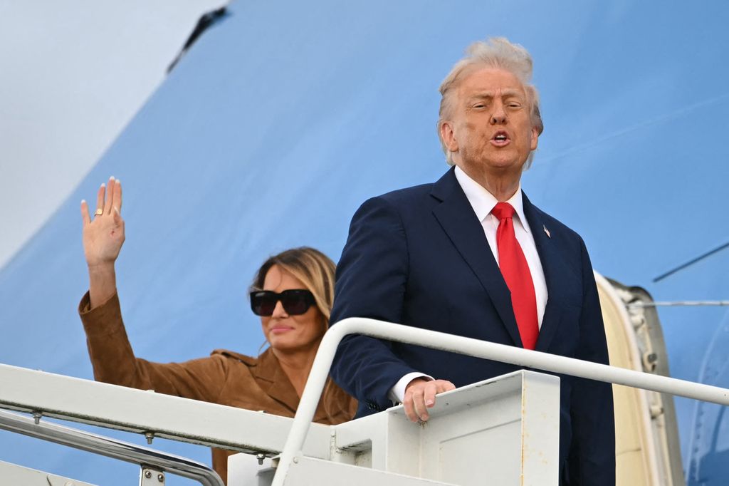 Donald Trump (R) gestures as he and US First Lady Melania Trump (L) board Air Force One at Stansted Airport, in Stansted, north of London, on September 18, 2025, to leave at the end of the US President's second State Visit