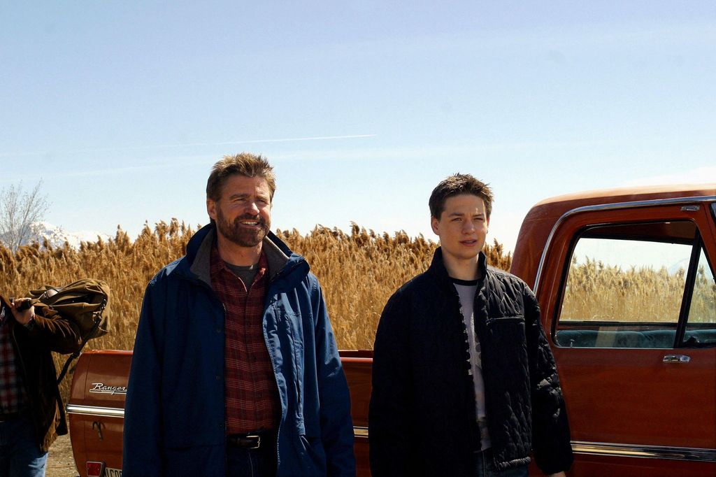 man and son standing by truck 