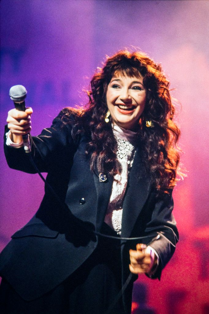 N'appelez pas Kate Bush un «reclus»: à l'intérieur de sa vie très privée avec un mari et un fils célèbres 2 Kate Bush tenant le microphone