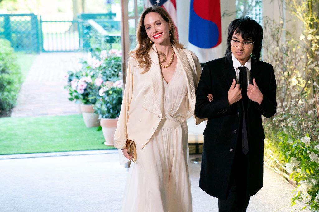 Angelina Jolie dressed in white, with her son Maddox