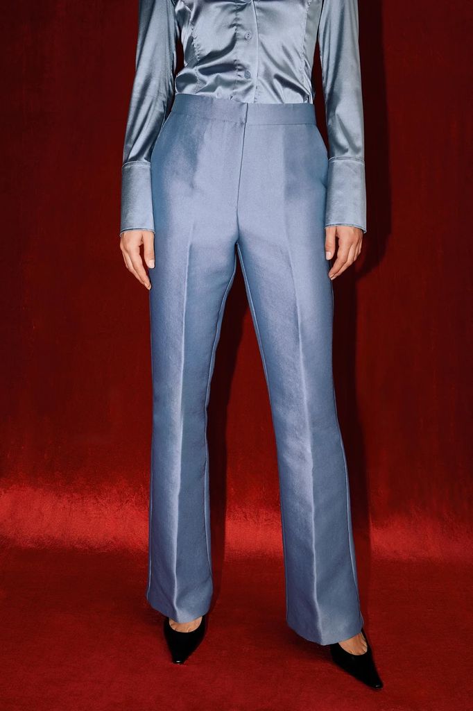 model posing in satin blue trousers