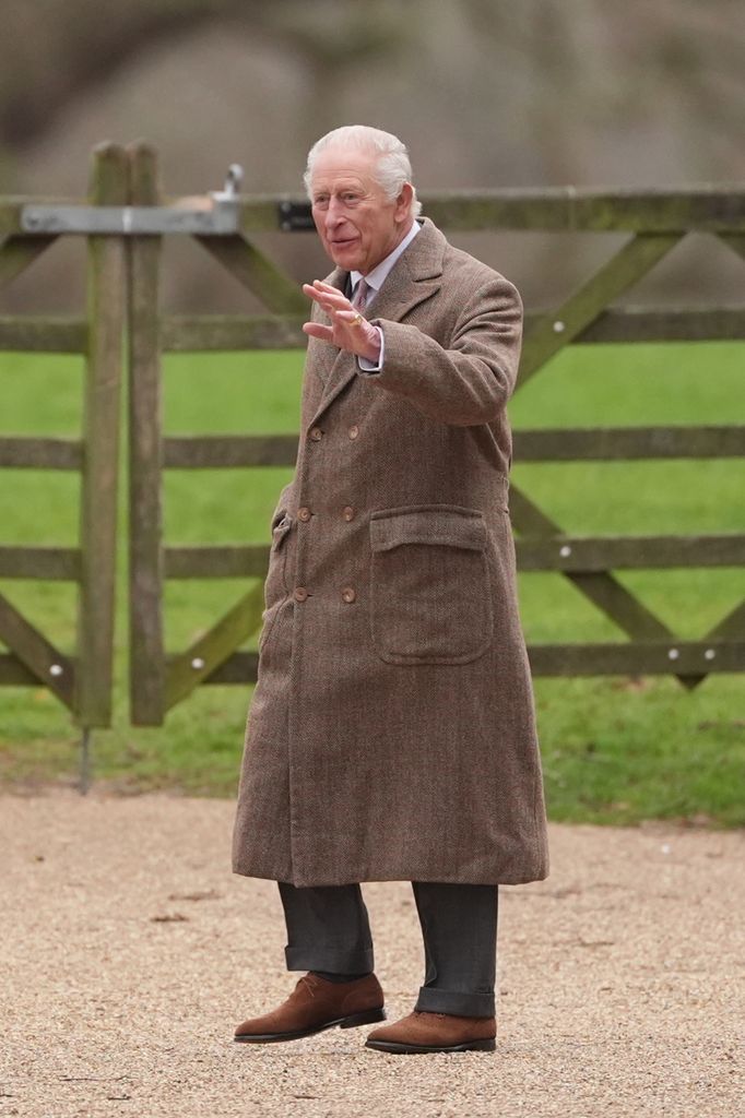 king charles in coat waving outside