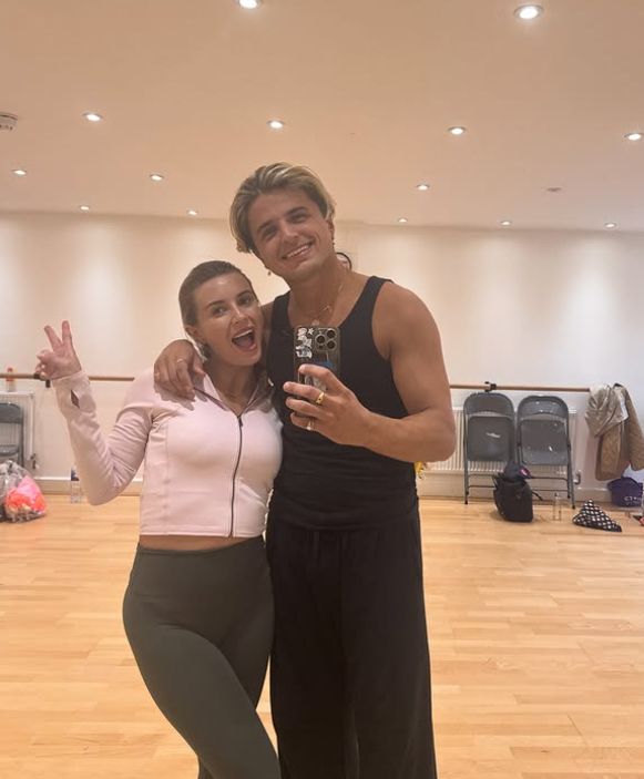 Dani Dyer and Nikita Kuzmin posing together in a training room