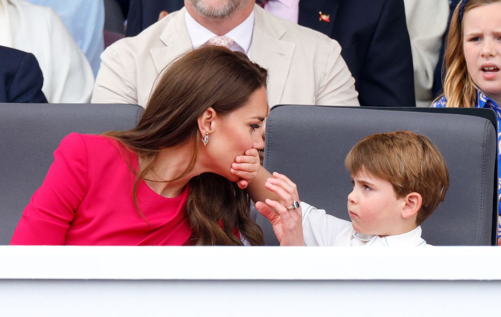 Prince Louis with his hand over Kate's mouth