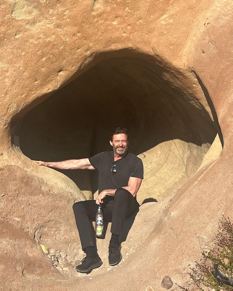 Hugh Jackman sitting on rocks in California