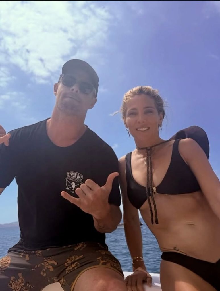 Elsa Pataky in black bikini and Chris Hemsworth in T-shirt posing on boat