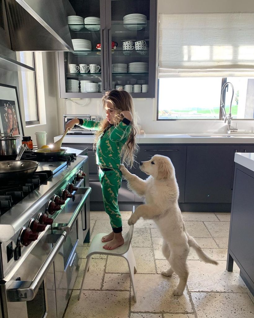 Kourtney Kardashian's son Reign cooking in the kitchen with a puppy