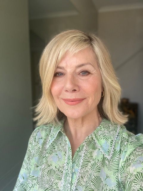 Selfie of a woman in her sixties smiling in a floral print green shirt