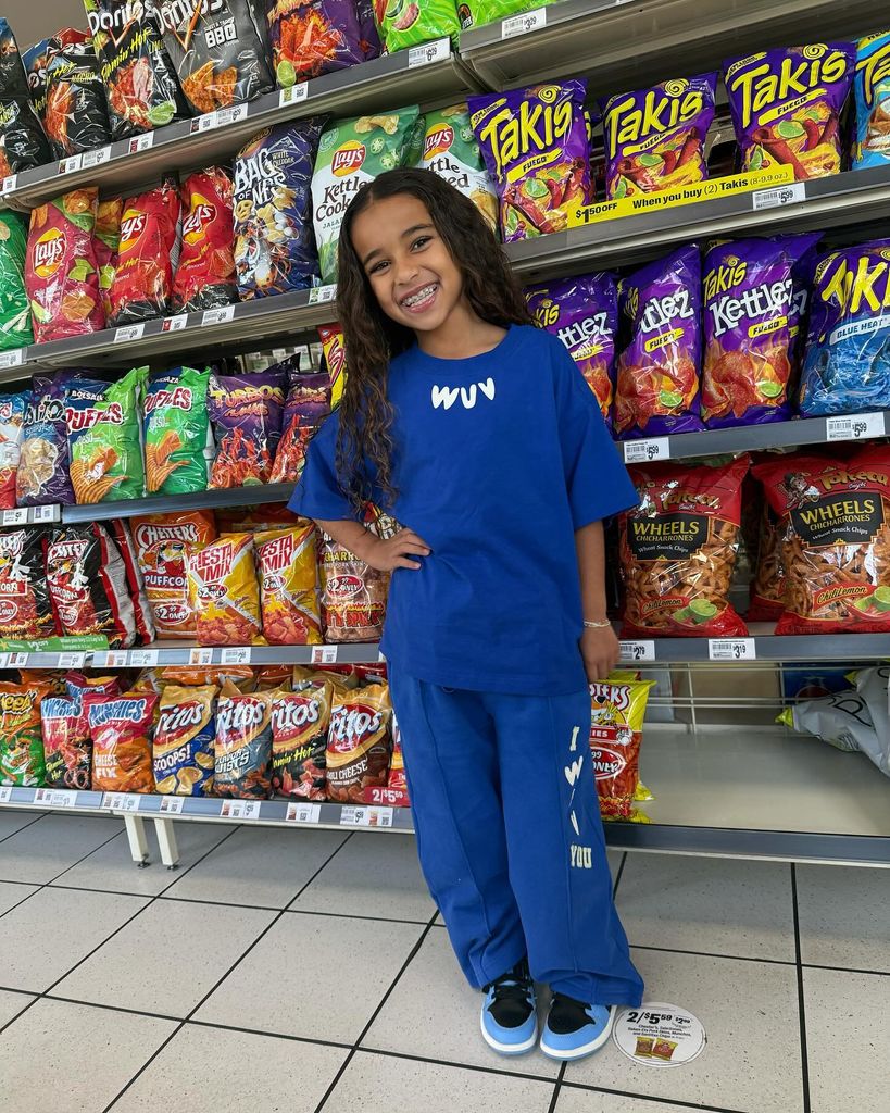 Dream Kardashian poses in front of chips in the supermarket