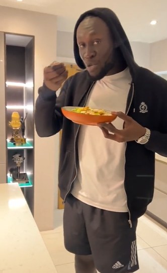 Stormzy in his kitchen with his awards in the background