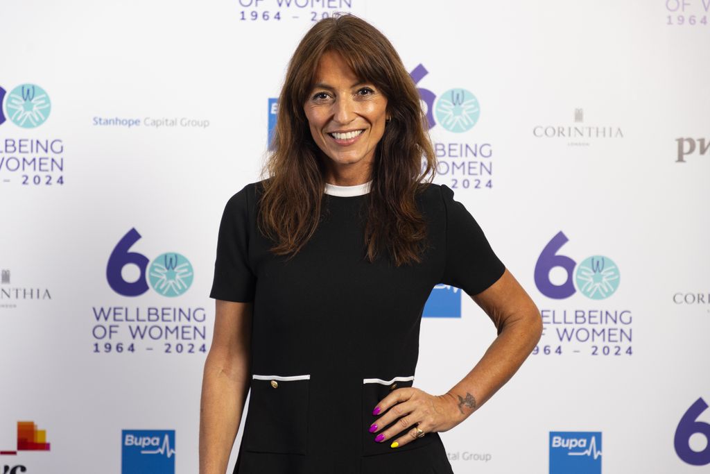 Davina McCall smiling in a black mini dress