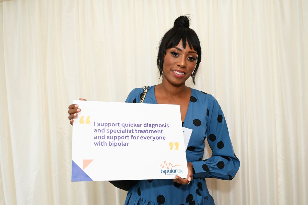 Leah Charles-King holding a sign for Bipolar UK