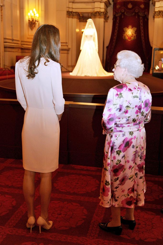 Queen Elizabeth II and Princess Kate view her wedding dress at the Buckinham Palace exhibition