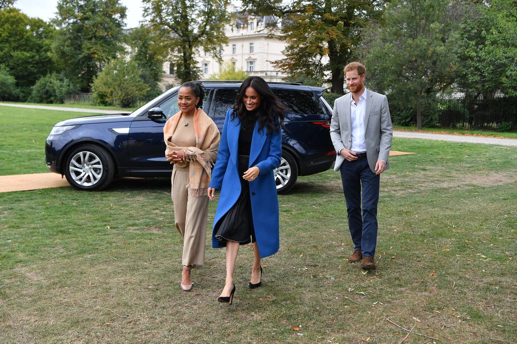 The Duchess of Sussex in a blue coat with her mother Doria Ragland in cream and Prince Harry at Kensington Palace