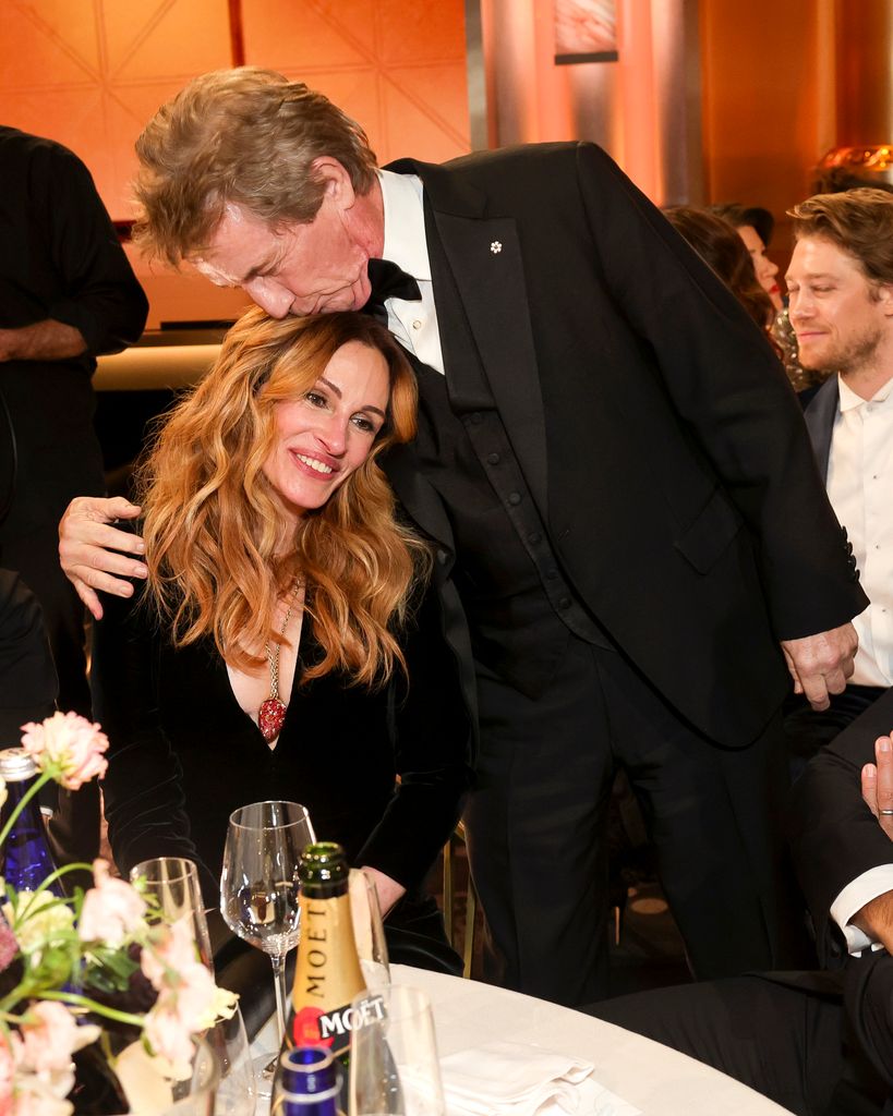 man kissing woman's forehead