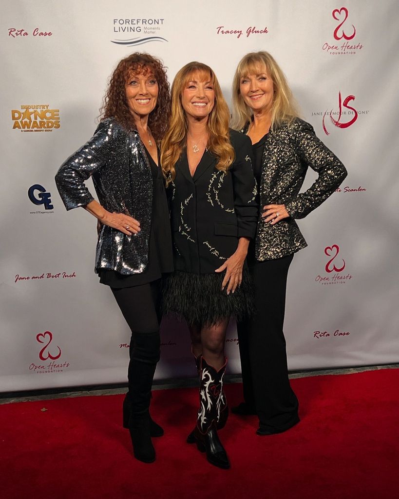 three sisters in black on red carpet