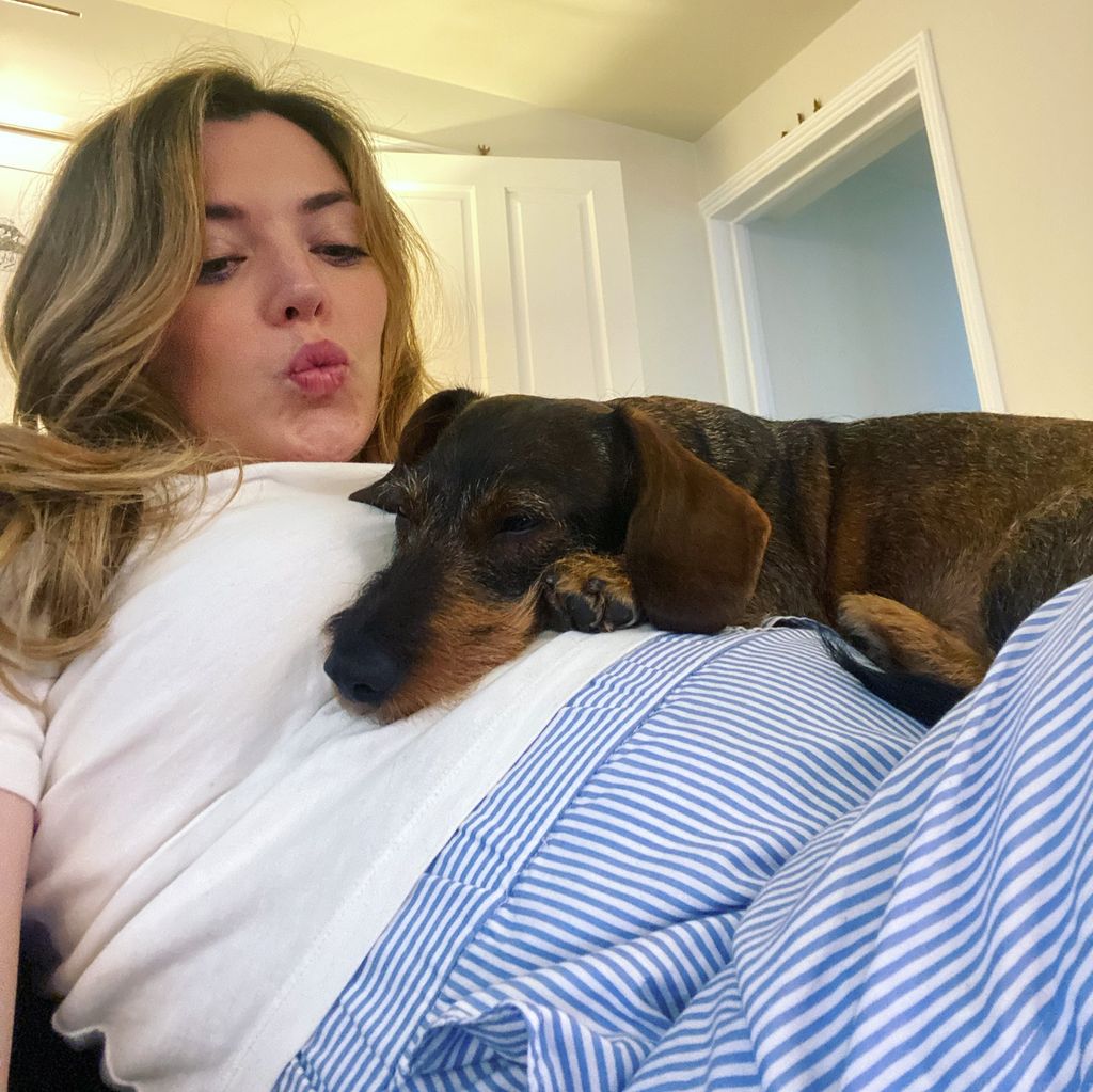 woman sitting on sofa with pet dog 