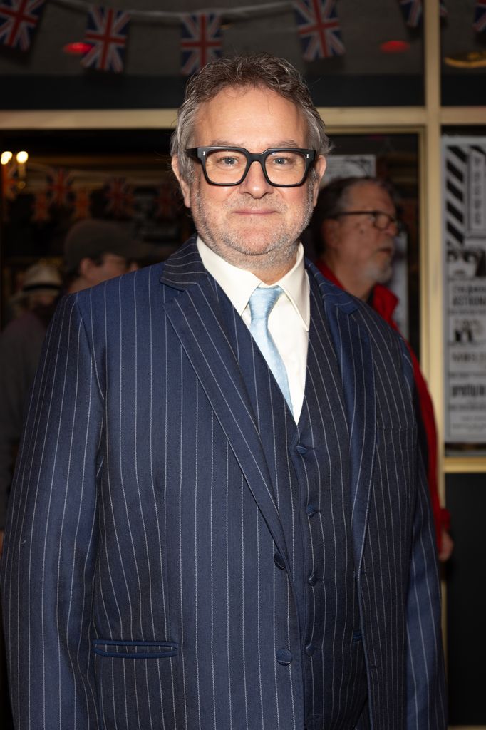 Man in pinstripe suit posing for photo