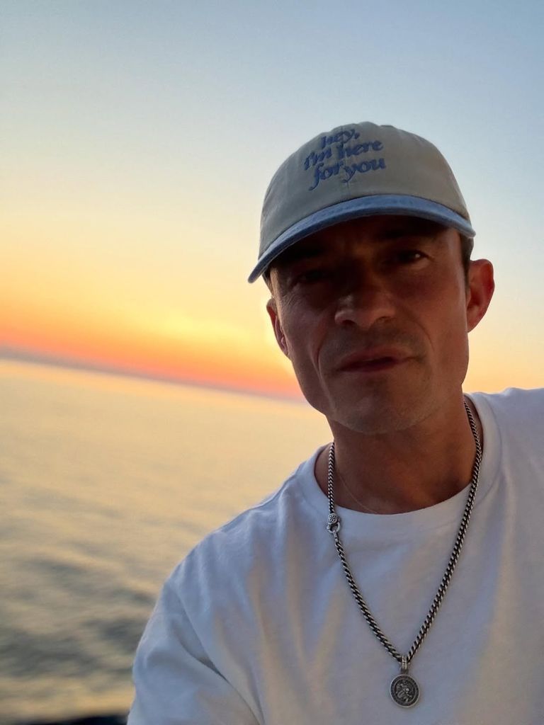 Orlando Bloom takes a selfie wearing a baseball cap by the sea in a photo shared on Instagram