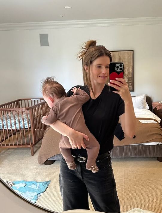 Katherine Schwarzenegger holding a baby boy inside a bedroom