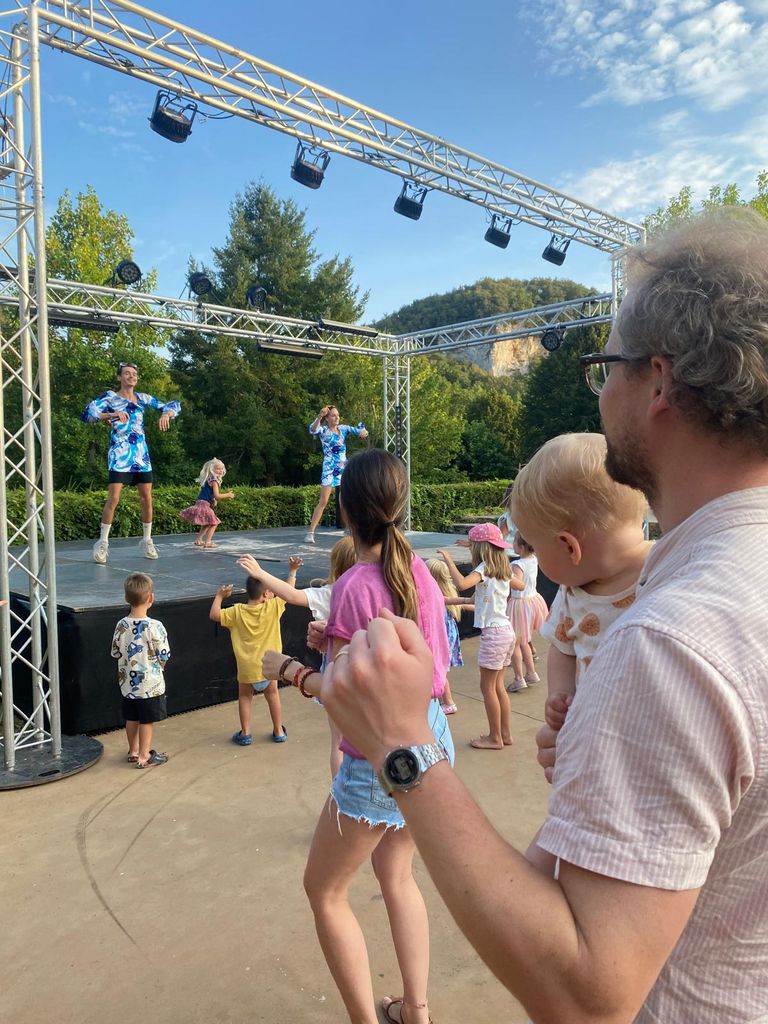 Adults and children dancing by a stage