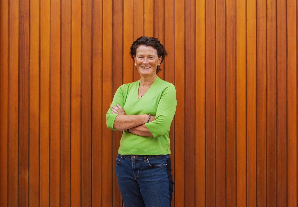 Woman in green against wooden background 