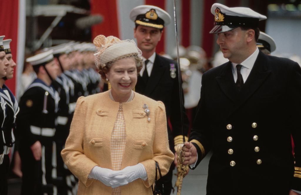 Sir Timothy Laurence walking behind Queen Elizabeth at a navy inspection