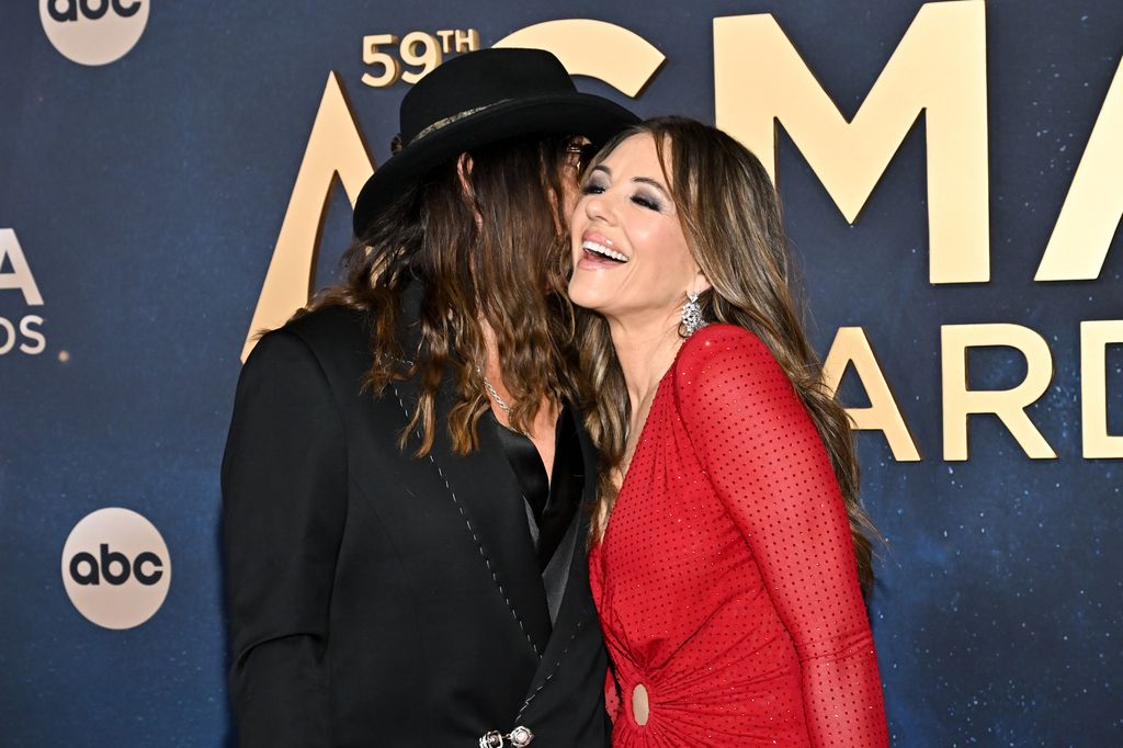 photo of billy ray cyrus and elizabeth hurley laughing cmas 2025