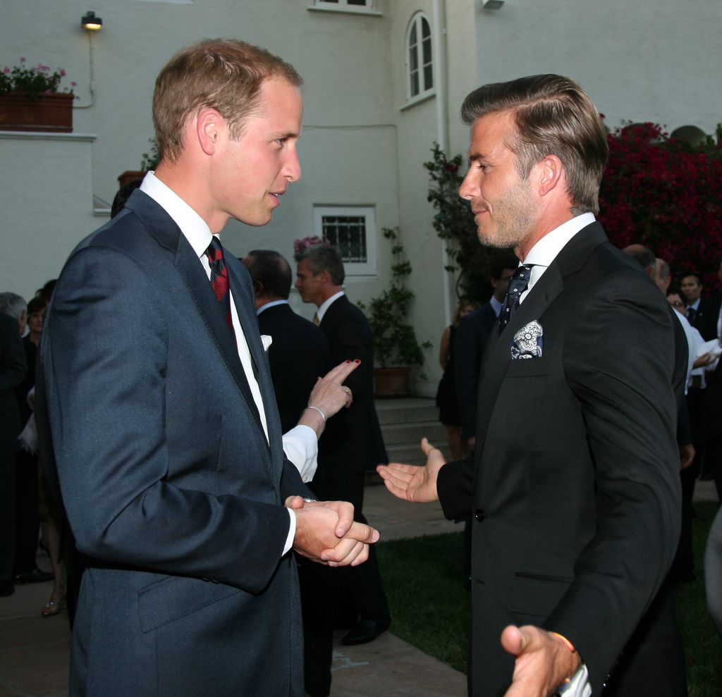 Prince William and David Beckham in suits talking to each other