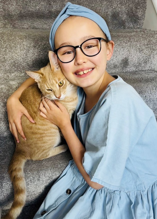 girl hugging ginger cat