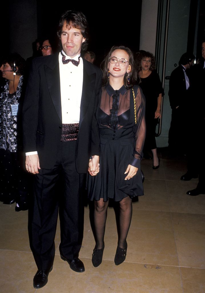 The couple hold hands black tie event