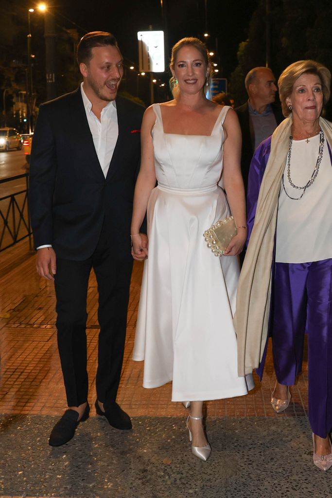 Matthew Kumar holding the hand of Princess Theodora as they walk with Queen Anne-Marie