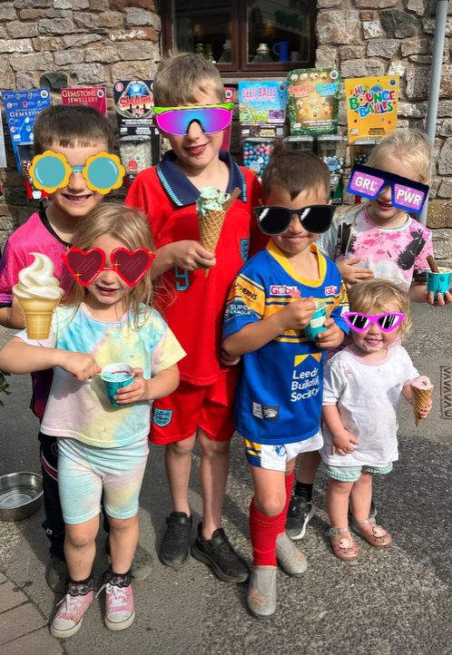 Six children holding ice cream cones in animated sunglasses