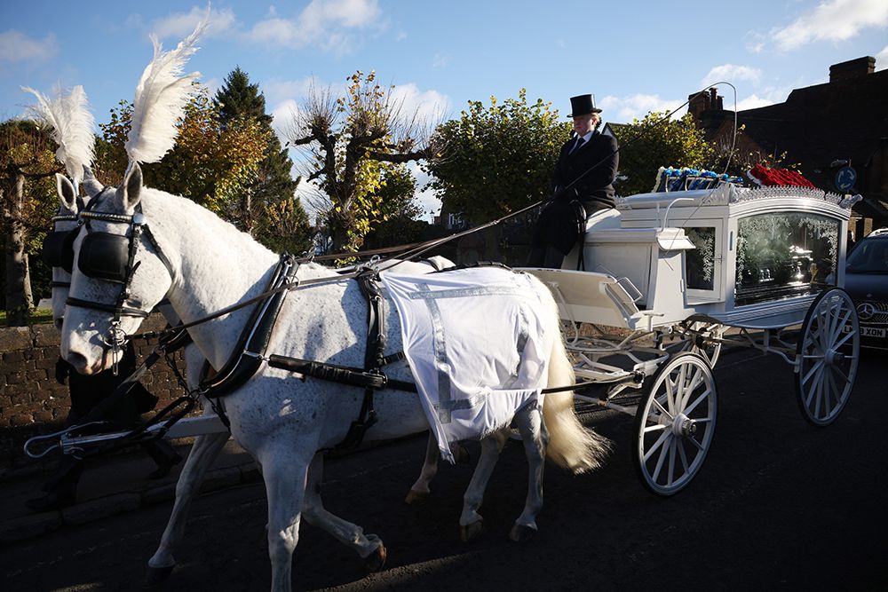 A horse drawn hearse arriving at the funeral of Liam Payne