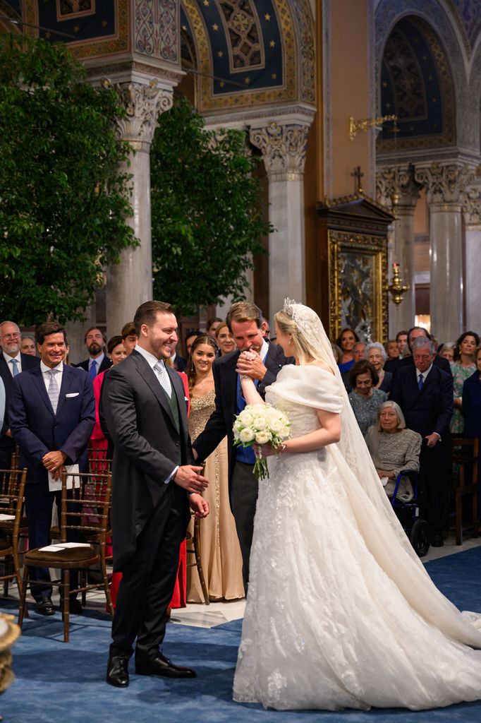 Prince Pavlos kissing sister Theodora's hand at the altar