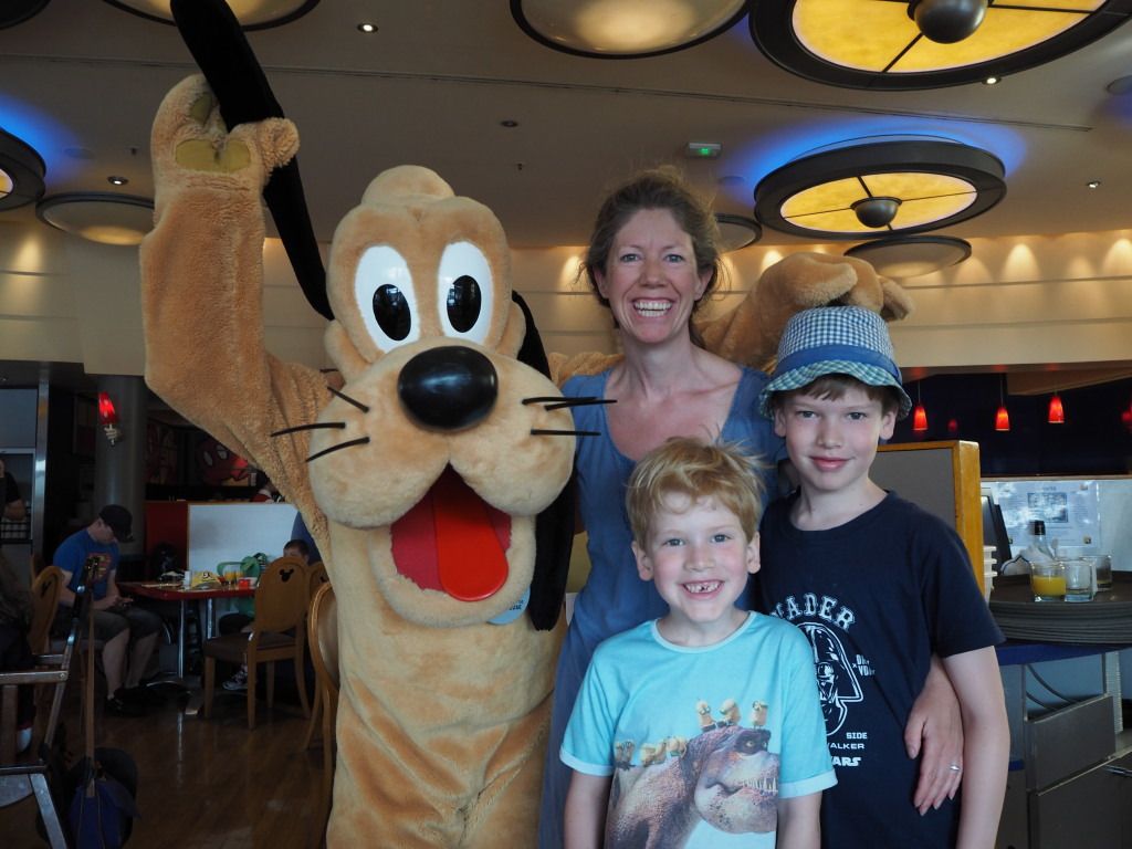 A mother and her two sons posing with Pluto