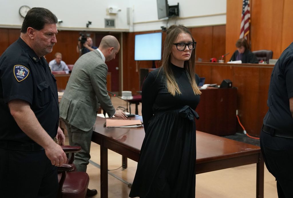 With attorney Todd Spodek (L) and Judge Diane Kiesel (R) in the background, fake German heiress Anna Sorokin is led away after being sentenced in Manhattan Supreme Court May 9, 2019 following her conviction last month on multiple counts of grand larceny and theft of services