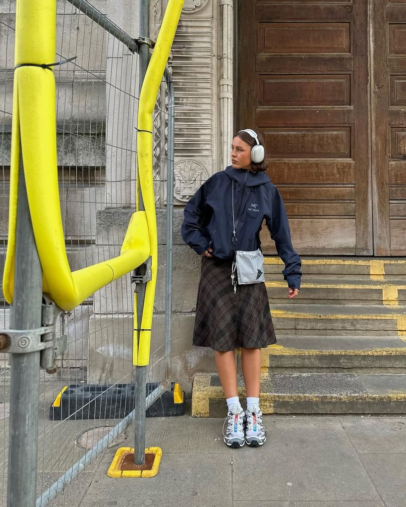 Olivia Hirst in blue waterproof jacket and plaid skirt