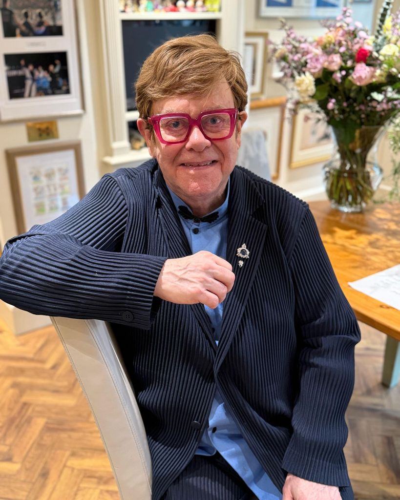Elton john smiling at camera at home