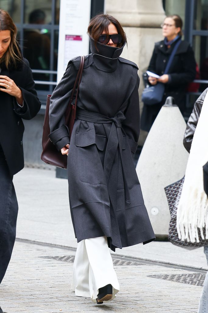 Victoria Beckham on street in huge black trench coat