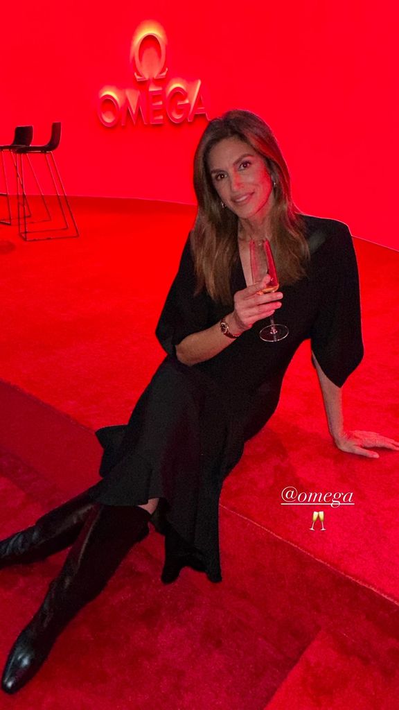 Cindy Crawford in black dress in red room