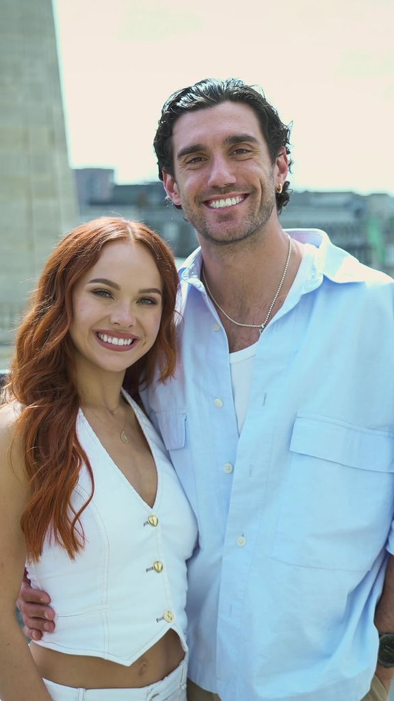 A woman in white and a man in blue pose together