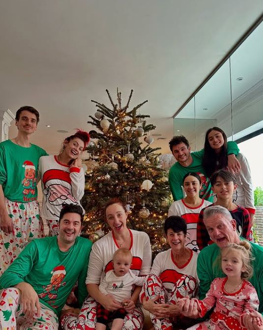 A large family gathered around a Christmas tree