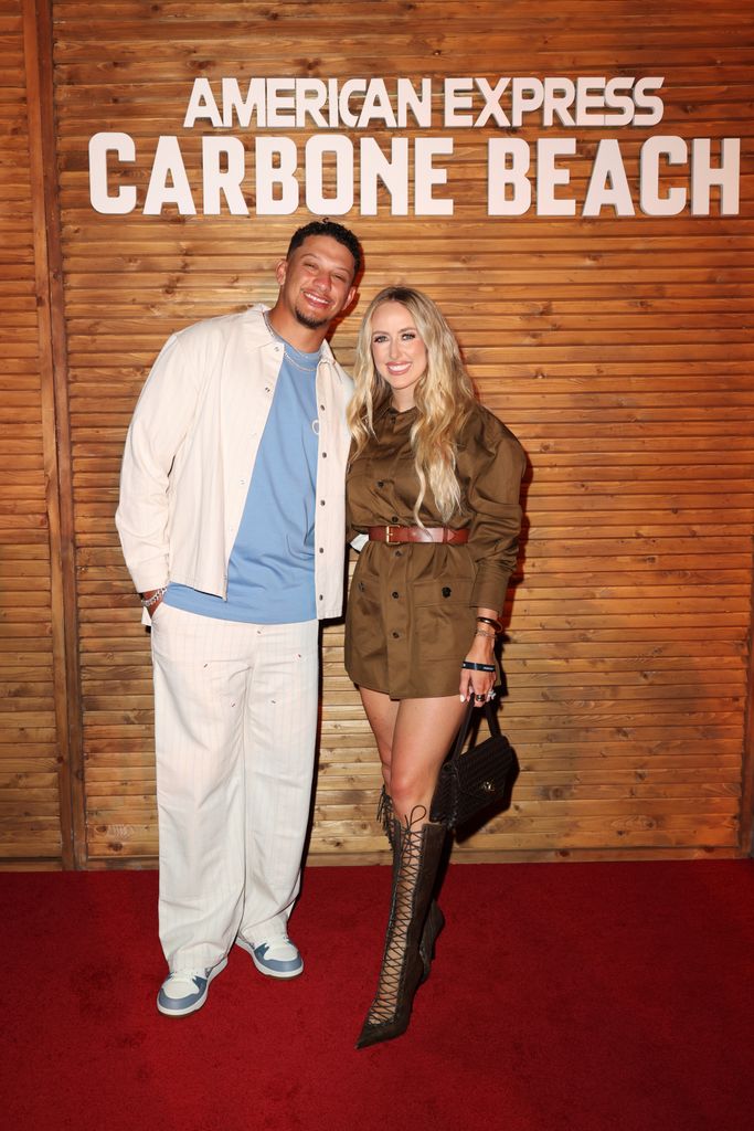 Patrick Mahomes et Brittany sourient devant la caméra lors d'un événement