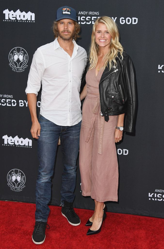 Eric Christian Olsen and Sarah Wright smile as they post on red carpet