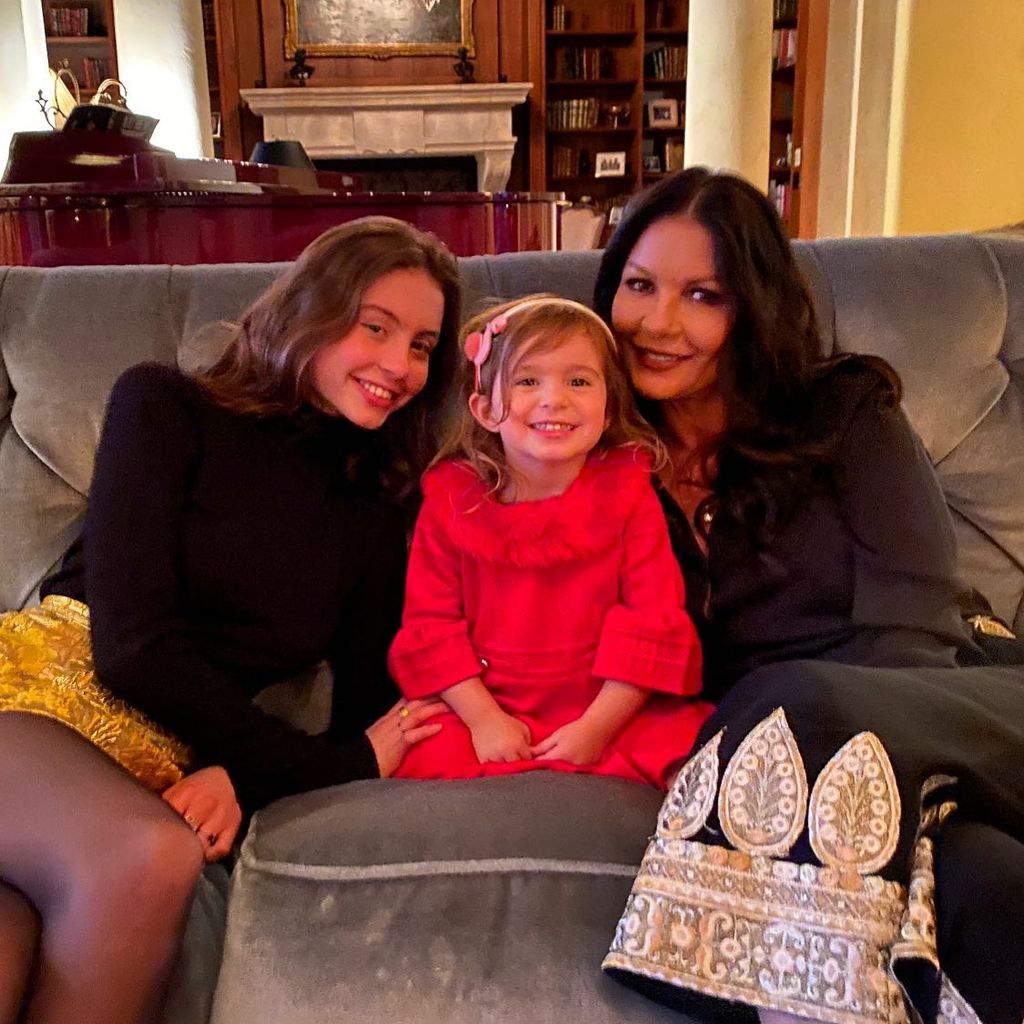 Cameron douglas' daughter on sofa smiling with Catherine zeta jones and Carys douglas
