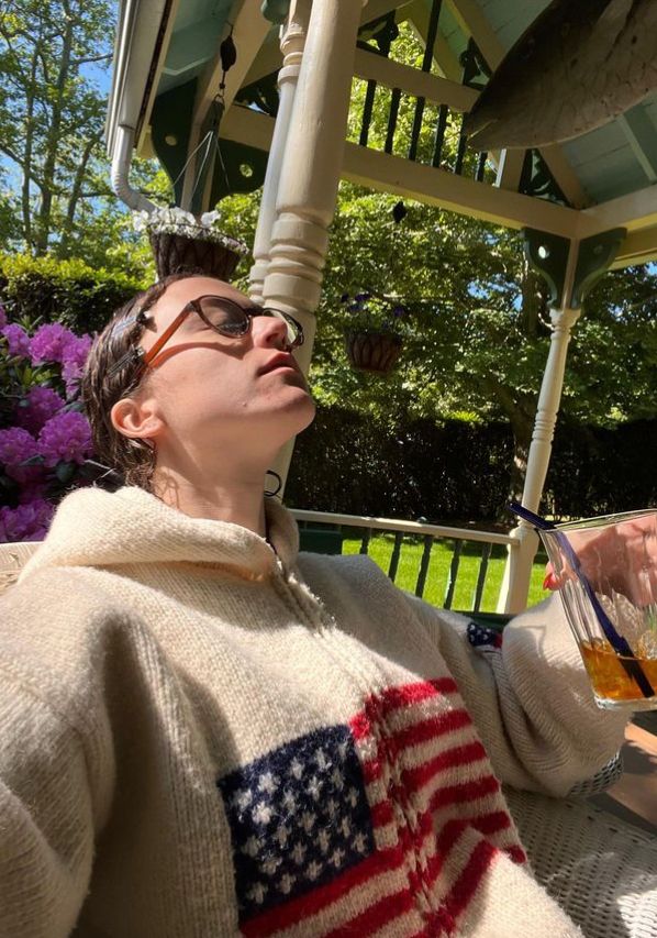 Ella Emhoff relaxing in woolen jumper with United States flag on it